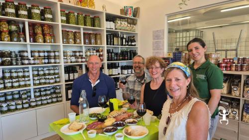 Eine Gruppe mit Weingläsern an einem Tisch mit Oliven, Brot, Wurstwaren und Käse während einer Verkostung in Salerno