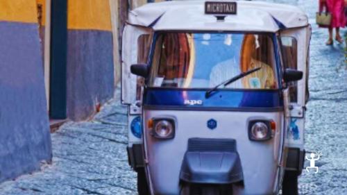 Turisti a bordo di un taxi locale a Procida, esplorando Terra Murata e altri luoghi iconici. Un'esperienza perfetta per gruppi, team building e addii al celibato/nubilato in Campania