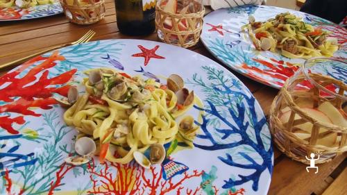 Linguine con vongole, zucchine e pomodorini, piatto gourmet servito a bordo, esperienza in Campania