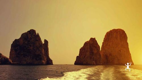 Vista dei Faraglioni di Capri al tramonto durante il tour in barca, perfetta per coppie e fotografi in cerca di scorci unici in Campania