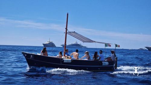 Vista ravvicinata dei Faraglioni di Capri durante un tour condiviso in barca, perfetto per gruppi e team building in Campania