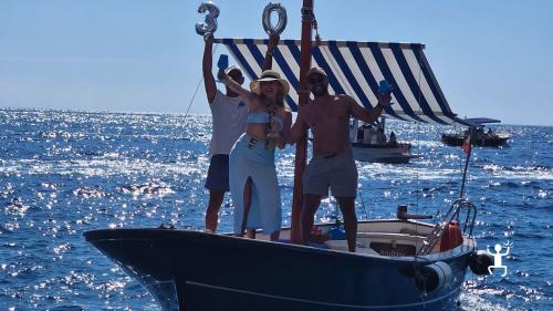 Vivi Capri in un tour dell’isola in barca tradizionale che attraversa i Faraglioni, perfetto per team building e gruppi