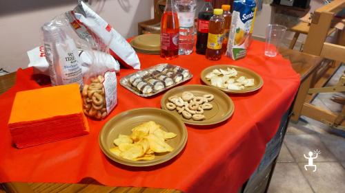 Tavolo con taralli, patatine, dolci e bevande preparato per l’aperitivo nella bottega di tessitura a Bisaccia.