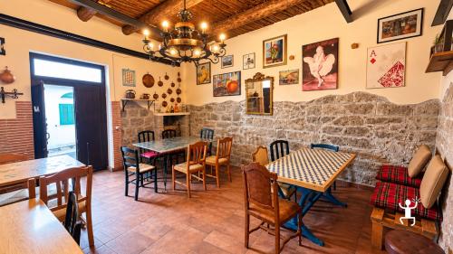 Interno del locale a Castel Morrone con tavoli, sedie in legno, pareti in pietra, quadri e soffitto con travi a vista.