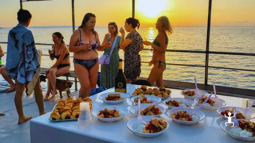 Tour panoramico in scafo amotore nel Cilento con apericena, musica e tramonto per famiglie e team building in Campania