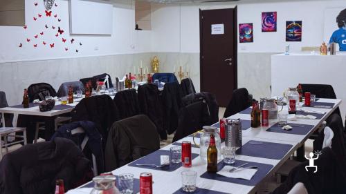 Tavoli apparecchiati con piatti, bicchieri e bevande nella sala dedicata ai partecipanti del corso di pizza.