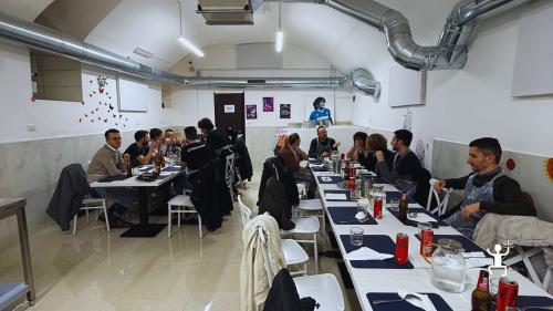 Partecipanti seduti ai tavoli nella sala del laboratorio di pizza a Napoli.