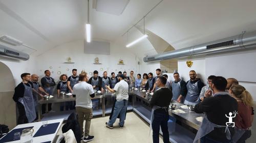 Gruppo di partecipanti riunito intorno ai banchi durante una lezione di pizza napoletana a Napoli