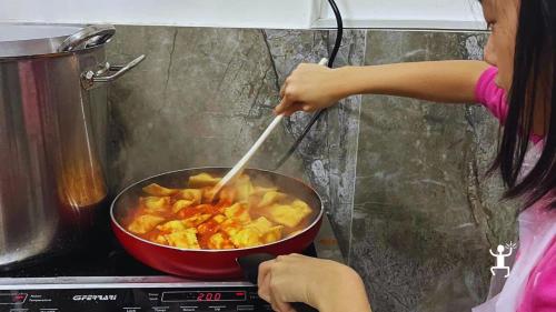 Eine Teilnehmerin rührt die Ravioli in der Tomatensauce während des Pastakurses in Neapel.