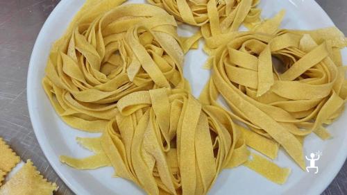 Frische Fettuccine-Nester auf einem Teller, zubereitet während des Kochkurses in der Altstadt von Neapel.